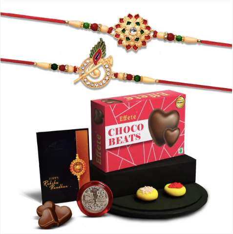 Designer Rakhi Combo Set – Krishna Flute & Floral Rakhis with Chocolates, Silver Coin & Greeting Card
